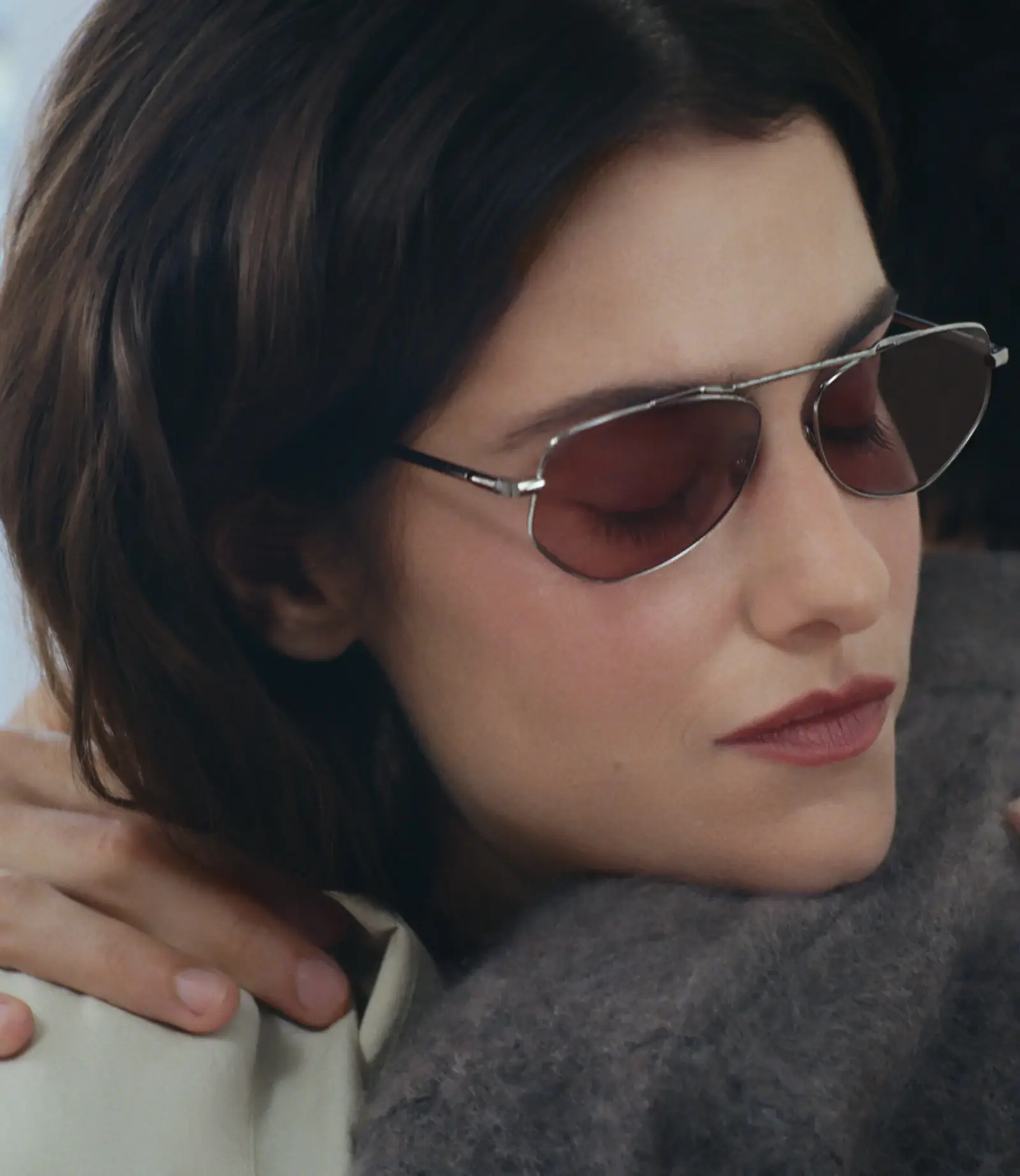 Femme portant des solaires AHLEM en métal fin, verres rosés, contre un pull gris